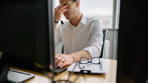 Salarié épuisé travaillant en bureau, illustration de l'inclusion professionnelle de l'autisme.